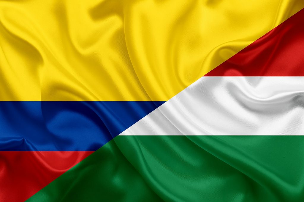 Waving flags of Colombia and Hungary merged together, symbolizing the new bilateral Working Holiday agreement effective from April 2025.