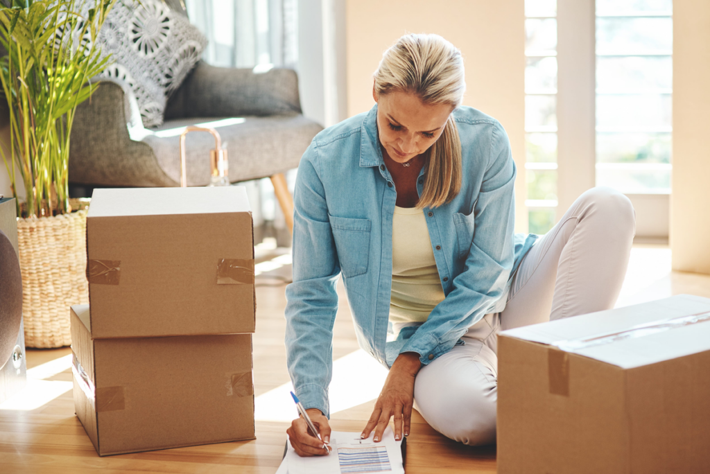Woman completing paperwork among moving boxes in her new home